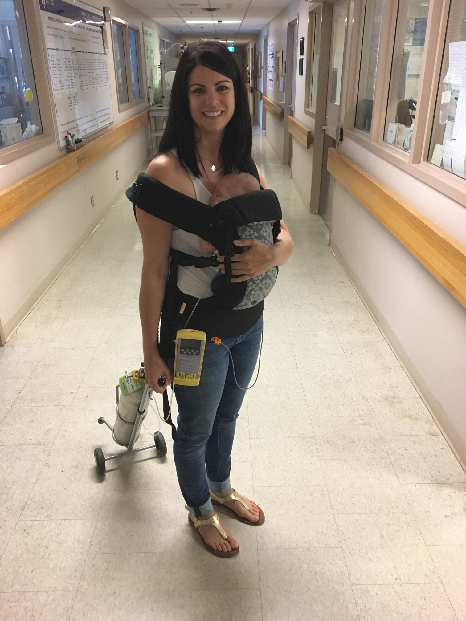 Jamie Eberts carrying baby Olivia and her oxygen tank