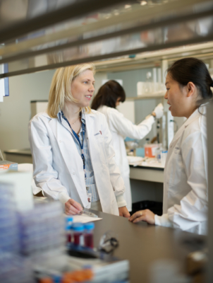 Dr. Rebecca Auer speaks with a colleague