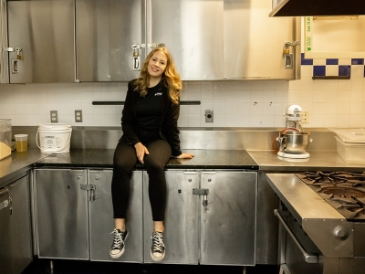Stefanie Scrivens sitting in a professional kitchen.