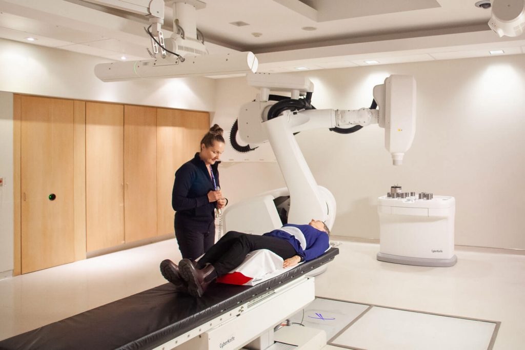 Julie Gratton with patient beside CyberKnife robot